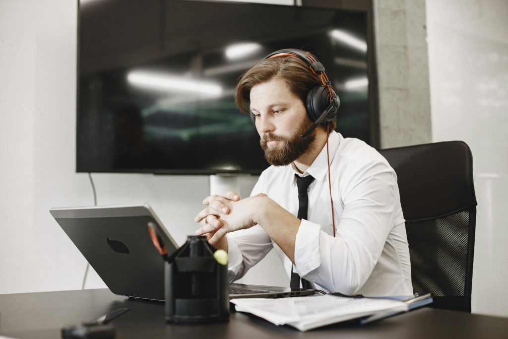 Focused professional man working remotely with headset in modern office setting.
